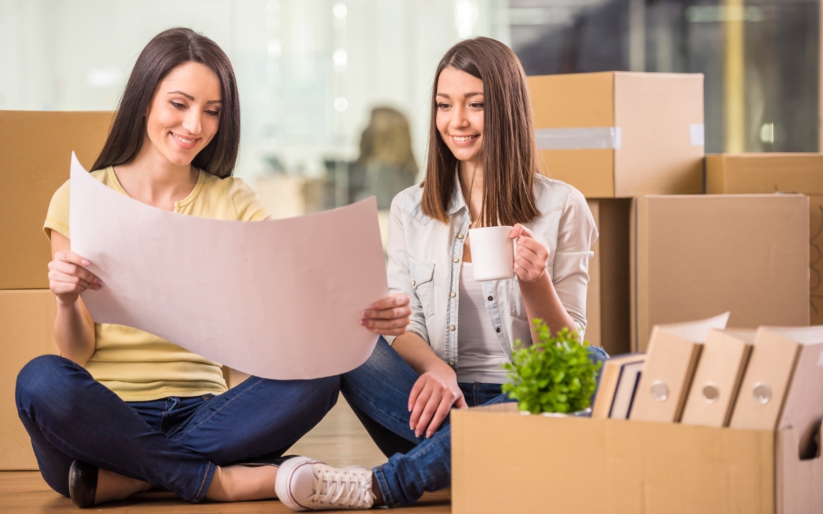 workers in office with boxes looking at plans 